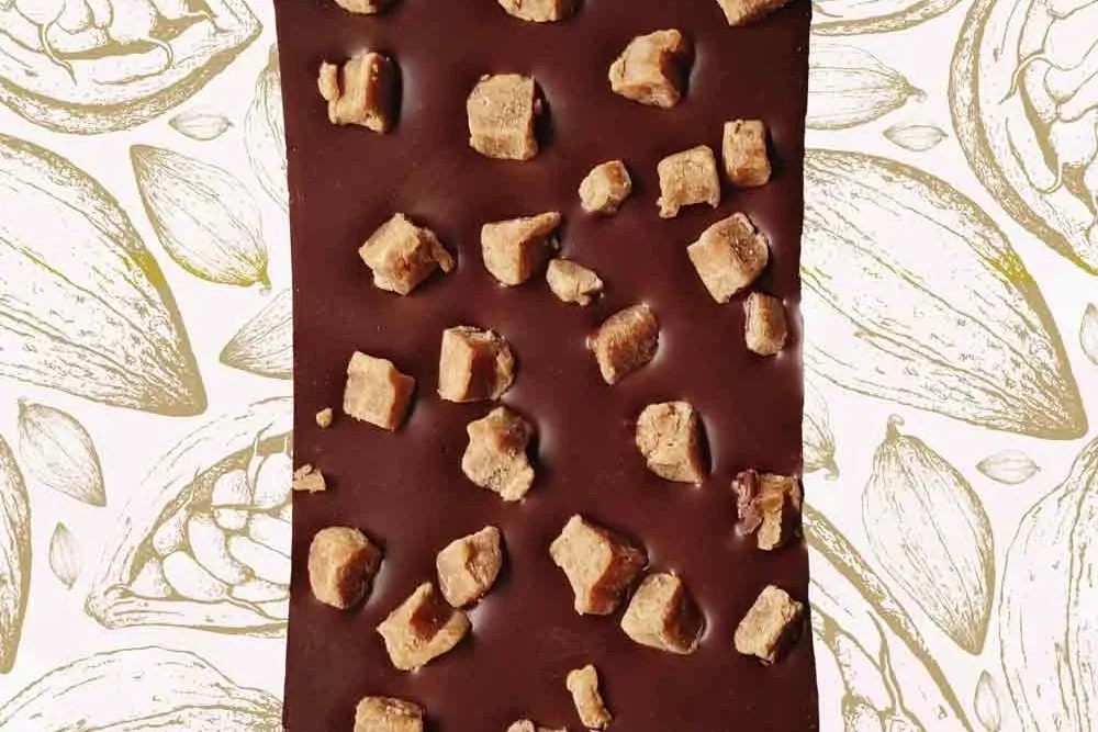 Milk chocolate bar squares placed on a table, demonstrating how much chocolate is toxic to dogs compared to darker varieties.